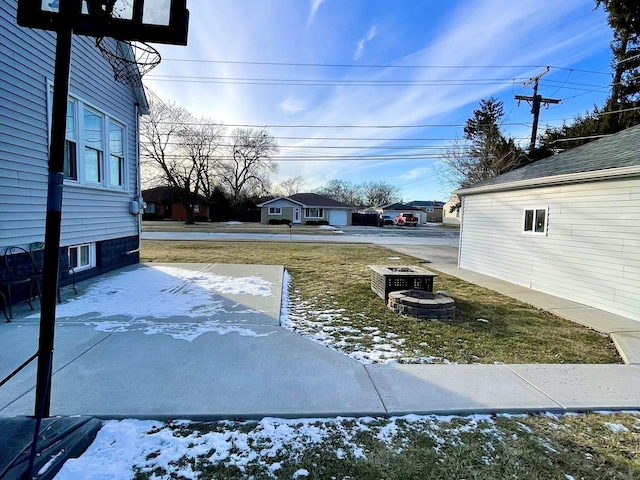 yard layered in snow with an outdoor fire pit