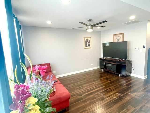 living room with ceiling fan and dark hardwood / wood-style flooring