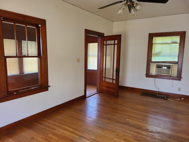 spare room with cooling unit, ceiling fan, and wood-type flooring