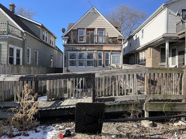 snow covered rear of property featuring a deck