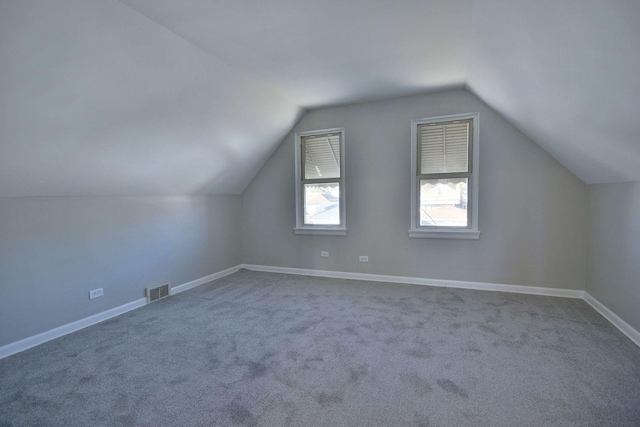 bonus room featuring lofted ceiling and carpet