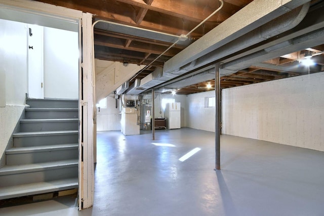 basement featuring white refrigerator and water heater