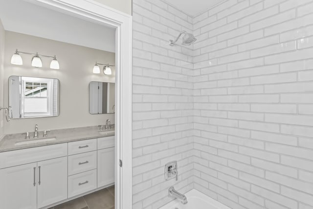 bathroom with tile patterned flooring, vanity, and tiled shower / bath