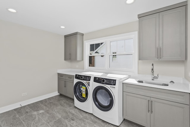 washroom featuring cabinets, washing machine and clothes dryer, and sink