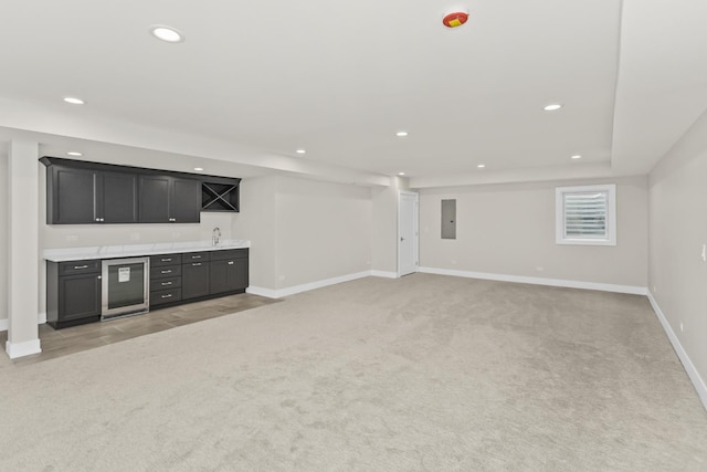 unfurnished living room with light colored carpet, indoor wet bar, wine cooler, and electric panel