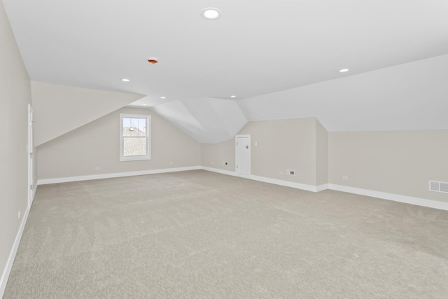 bonus room featuring vaulted ceiling and light colored carpet