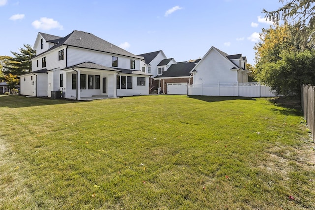 rear view of property featuring a yard and central air condition unit