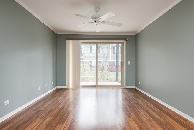 spare room featuring dark wood-type flooring, crown molding, baseboards, and ceiling fan