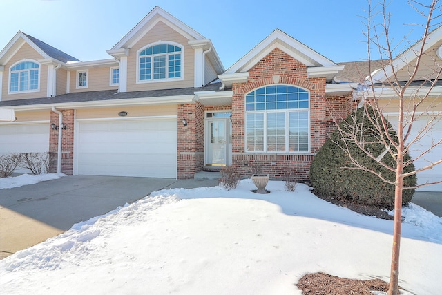 traditional home with a garage, concrete driveway, and brick siding