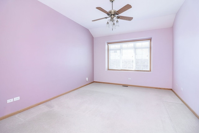 unfurnished room with light carpet, baseboards, vaulted ceiling, and a ceiling fan