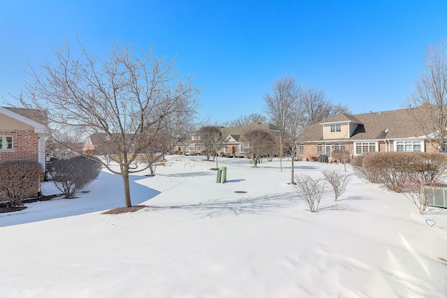 yard layered in snow featuring a residential view