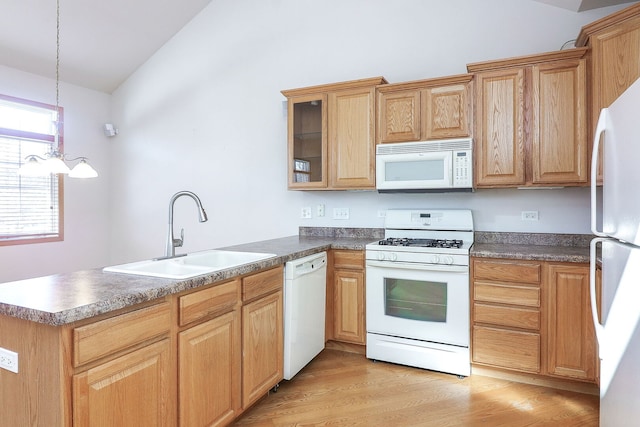 kitchen featuring light wood-style flooring, a peninsula, white appliances, a sink, and vaulted ceiling