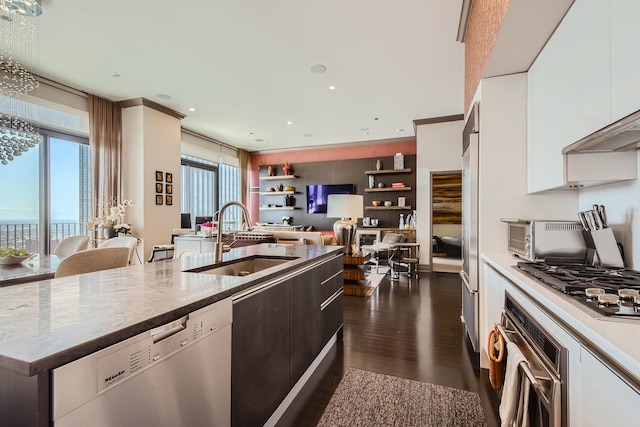 kitchen featuring sink, appliances with stainless steel finishes, white cabinetry, dark hardwood / wood-style floors, and a wealth of natural light