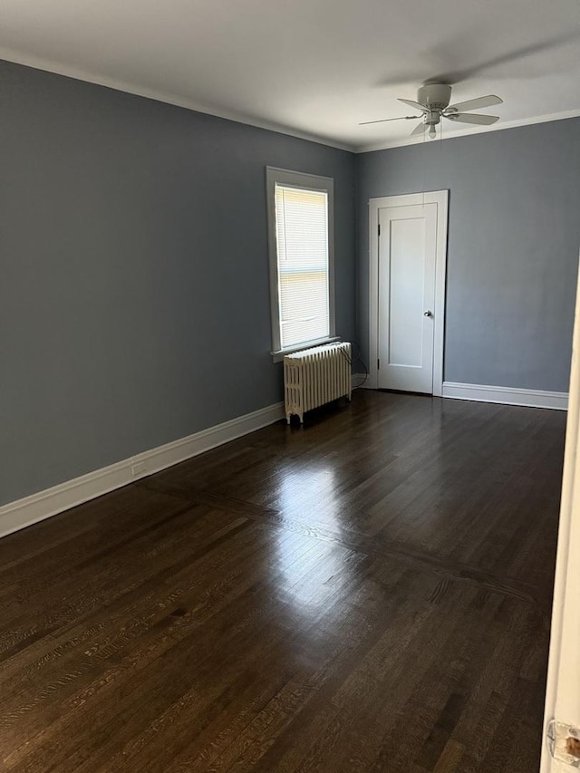 unfurnished room with crown molding, dark hardwood / wood-style floors, radiator heating unit, and ceiling fan