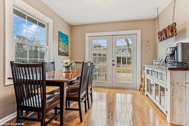 dining area with light hardwood / wood-style flooring and french doors