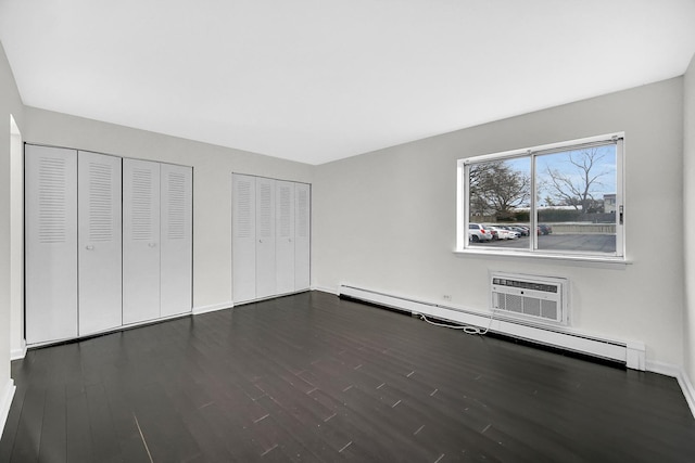 unfurnished bedroom with multiple closets, a baseboard radiator, a wall mounted air conditioner, and dark hardwood / wood-style floors