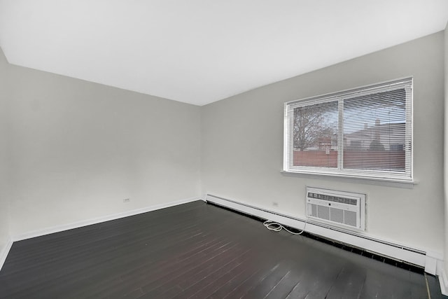 empty room featuring dark wood-type flooring, a wall mounted air conditioner, and a baseboard heating unit