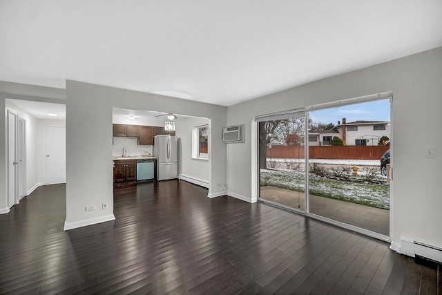 living room with a baseboard radiator, dark wood-type flooring, sink, and a wall mounted air conditioner