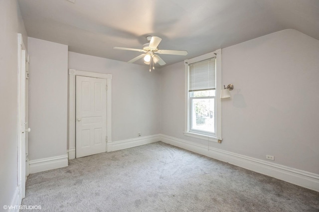 spare room with ceiling fan, light colored carpet, and lofted ceiling