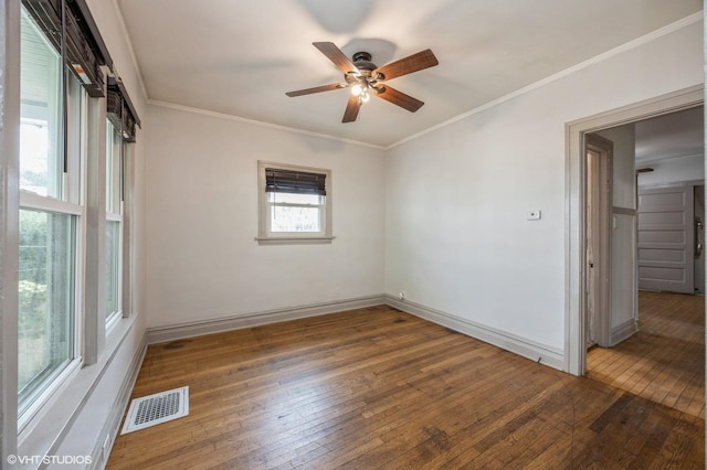 empty room with dark wood-type flooring, ornamental molding, and ceiling fan