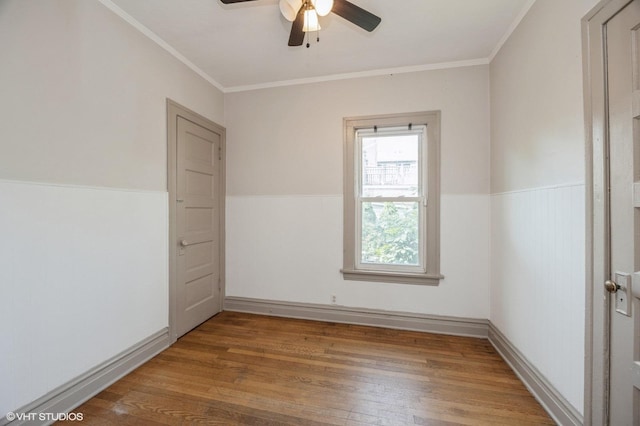 spare room with hardwood / wood-style floors, ornamental molding, and ceiling fan