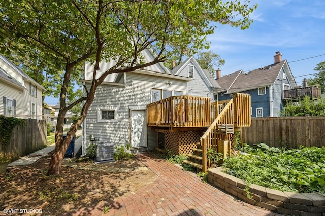 back of house with a deck and central air condition unit