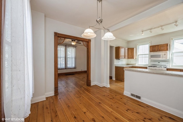 kitchen featuring stove, pendant lighting, and light hardwood / wood-style flooring