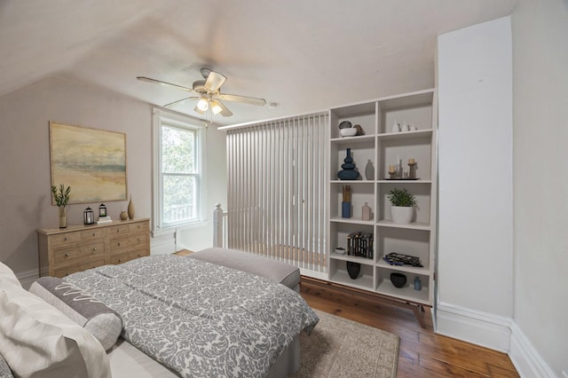 bedroom with dark wood-type flooring, ceiling fan, and vaulted ceiling