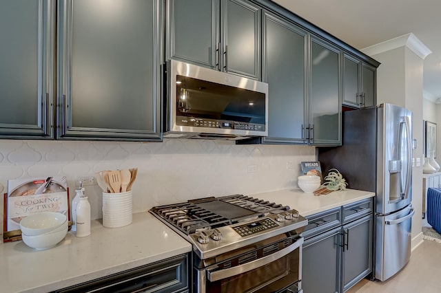 kitchen with backsplash, crown molding, and appliances with stainless steel finishes