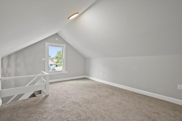 bonus room with lofted ceiling and carpet flooring