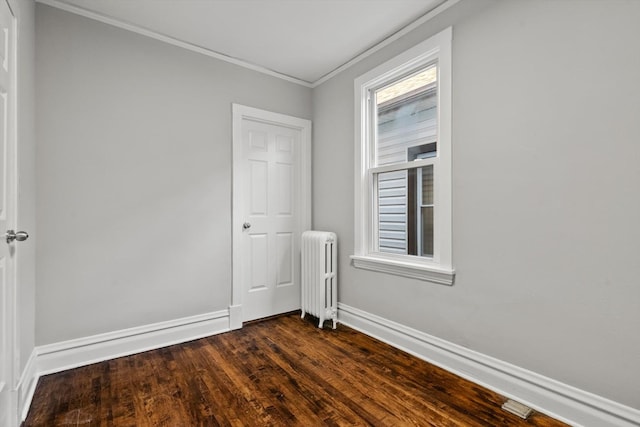 spare room featuring ornamental molding, plenty of natural light, dark hardwood / wood-style floors, and radiator