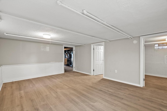 basement featuring hardwood / wood-style flooring and a textured ceiling