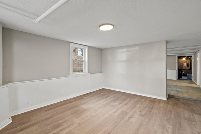 spare room featuring a textured ceiling and light wood-type flooring