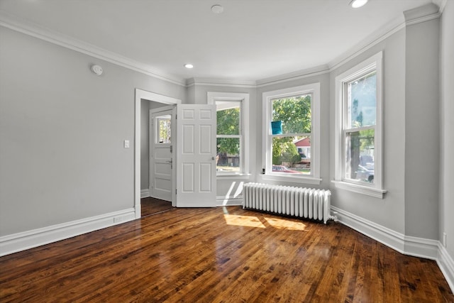 spare room with radiator, crown molding, and wood-type flooring