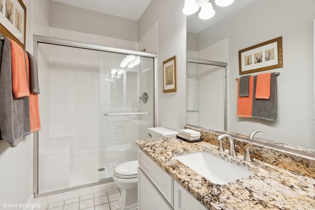 bathroom featuring toilet, a stall shower, tile patterned flooring, and vanity