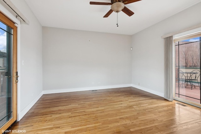 spare room featuring light wood-style floors, baseboards, visible vents, and a ceiling fan