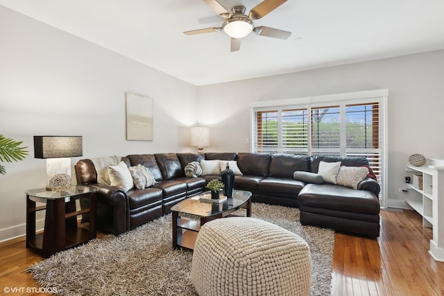 living room featuring ceiling fan, baseboards, and hardwood / wood-style floors