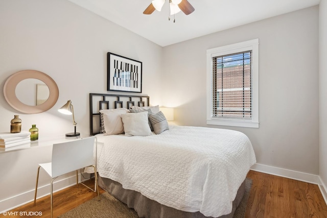 bedroom featuring a ceiling fan, baseboards, and wood finished floors