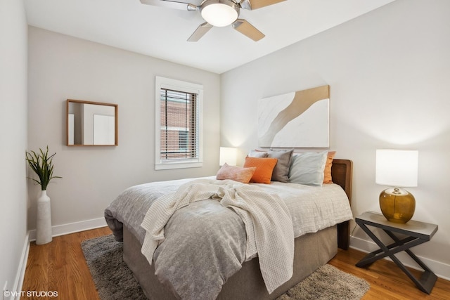 bedroom featuring a ceiling fan, baseboards, and wood finished floors