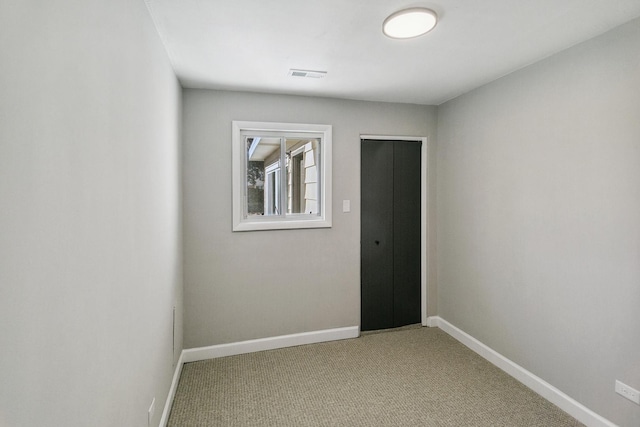 unfurnished room featuring light colored carpet