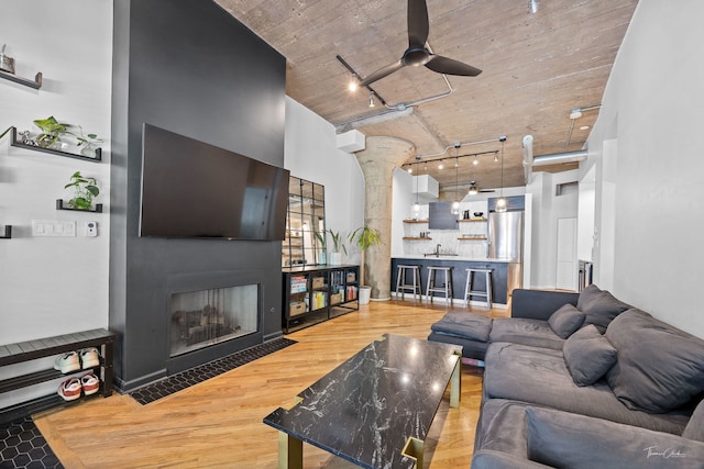 1000 W 15th St Unit 116, Chicago, IL 60608 - living area featuring wood finished floors, a ceiling fan, a fireplace with flush hearth, decorative columns, and rail lighting