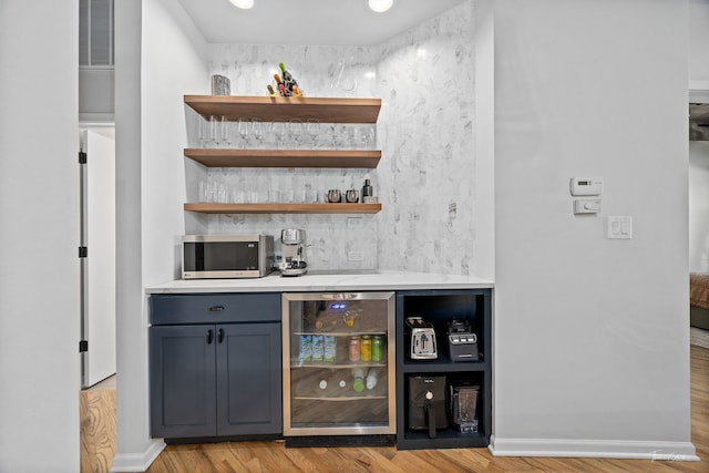 1000 W 15th St Unit 116, Chicago, IL 60608 - indoor dry bar with wine cooler, stainless steel microwave, light wood-style flooring, and baseboards