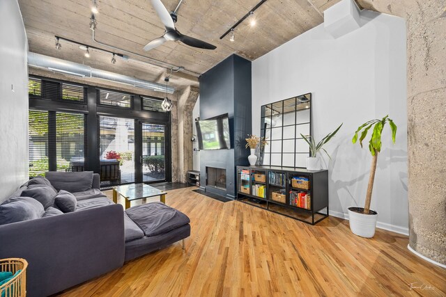 1000 W 15th St Unit 116, Chicago, IL 60608 - living room with track lighting, wood finished floors, a ceiling fan, a fireplace with flush hearth, and a high ceiling
