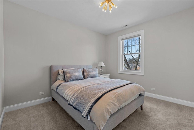 bedroom featuring light colored carpet and a chandelier