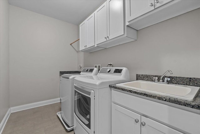 laundry area featuring cabinets, separate washer and dryer, and sink