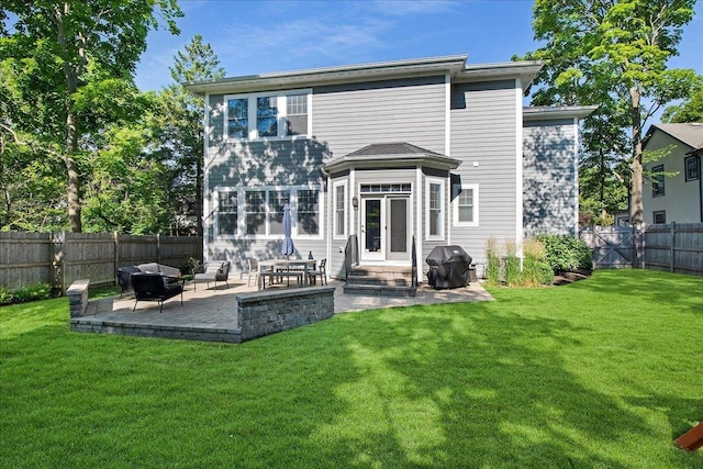 rear view of property featuring a lawn and a patio area