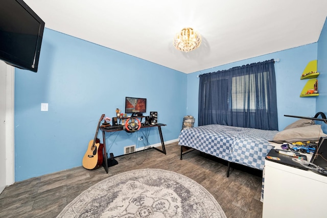 bedroom with dark hardwood / wood-style floors and a notable chandelier