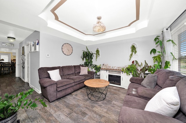 living room featuring a raised ceiling and dark hardwood / wood-style floors