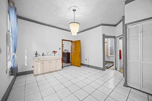 dining space with crown molding, a chandelier, sink, and light tile patterned floors