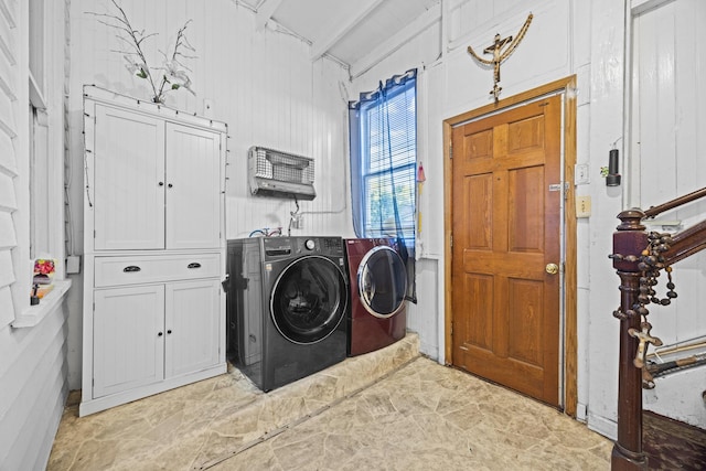 clothes washing area featuring cabinets and independent washer and dryer